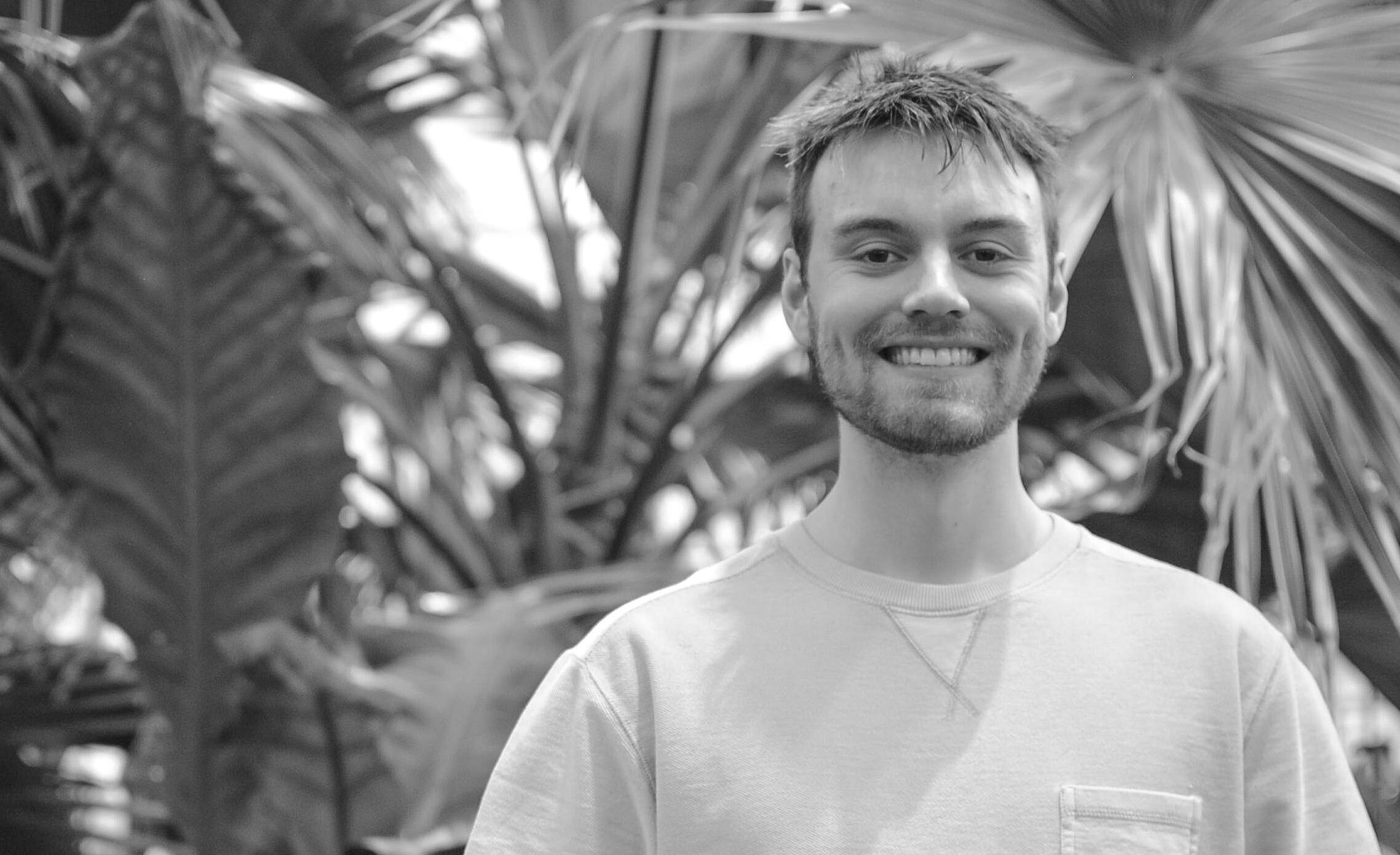 Professional head-shot of Ryan Callaghan with various flora in the background